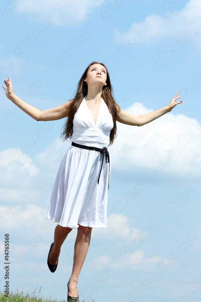 beautiful girl in a white dress on a background of the blue sky beautiful girl in a white dress on a background of the blue sky