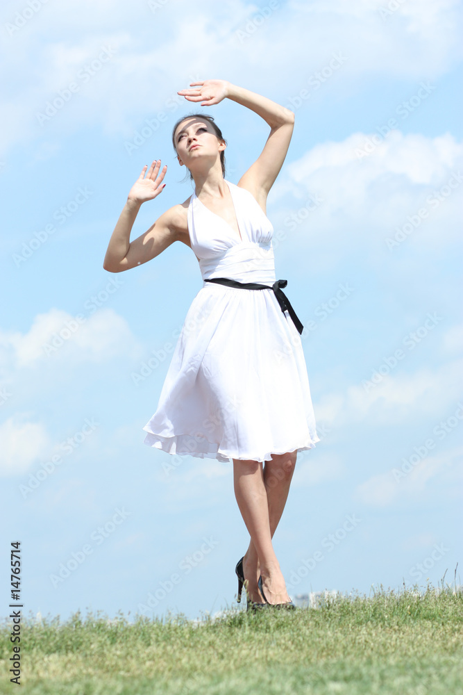 beautiful girl in a white dress on a background of the blue sky beautiful girl in a white dress on a background of the blue sky