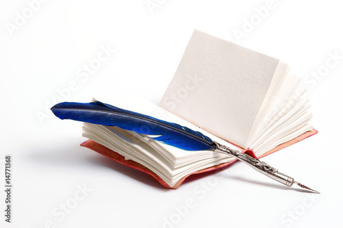 a blue writing feather on a diary on a white background