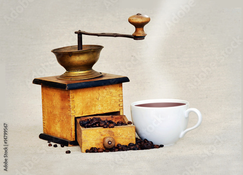 coffee mill and cup of hot black coffee