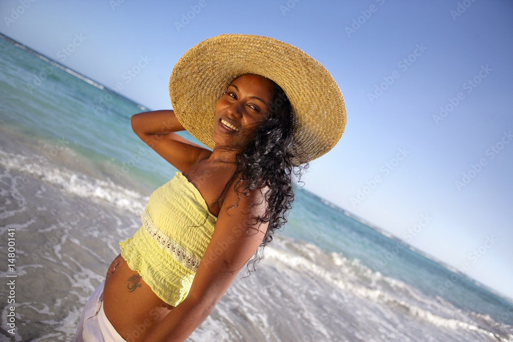 Jeune femmese portant un chapeau en bord de plage