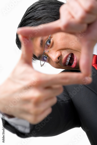 Asian businessman looking at his perspetive by framing his finge photo