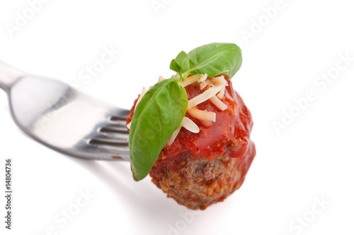 meatball with sauce, cheese and basil on a fork