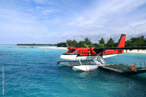 Red seaplane at the docks of an exotic resort in Maldives.