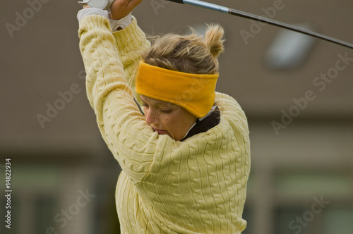 Female golfer swinging golf club close up