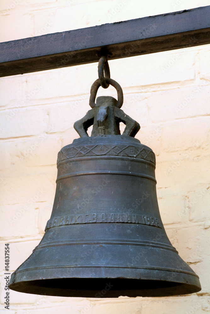 Solid Iron Bell on the Background of Wall