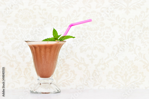 Chocolate milkshake with mint and straw