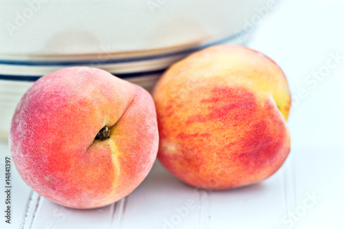 Fresh peaches by an antique bowl