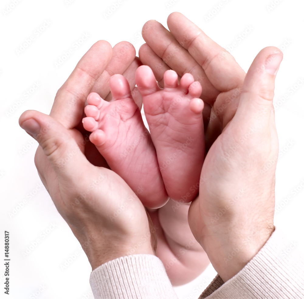 small baby feets lying on a father`s hands small baby feets lying on a father`s hands