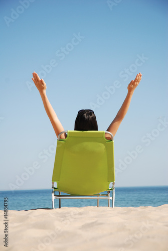 Happy woman sat on deck chair