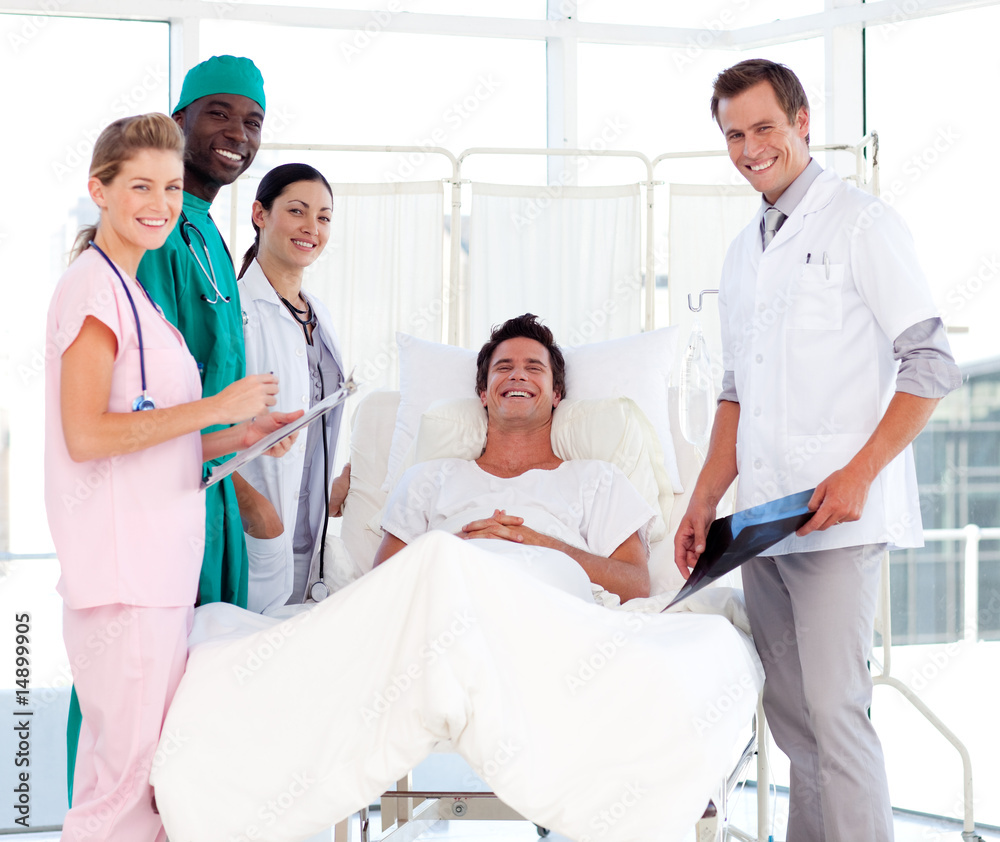 Doctors attending to a patient smiling at the camera Doctors attending to a patient smiling at the camera