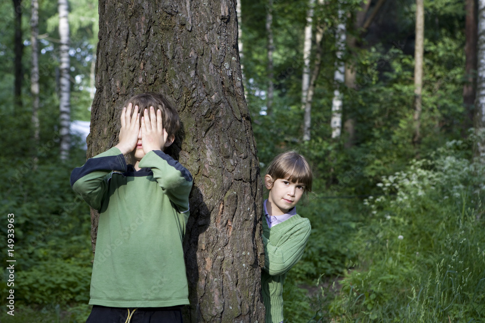 Girl and boy playing hide-and-seek Girl and boy playing hide-and-seek
