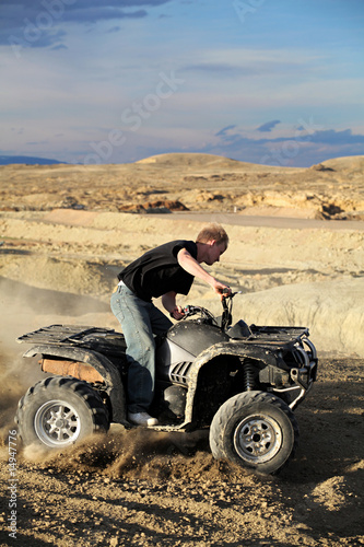 teen riding quad ATV in the hills