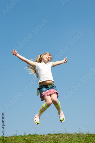 Little girl jumping against beautiful sky
