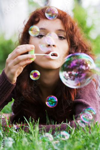 Young woman blowing bubbles.
