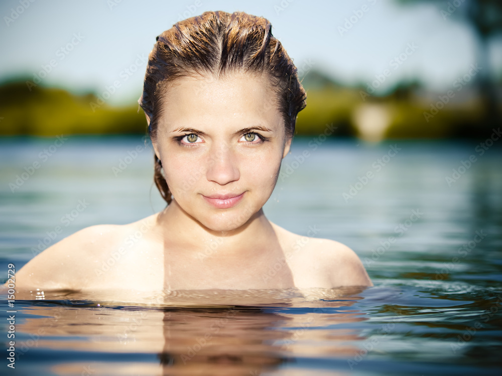 Young girl in the water with naked shoulders