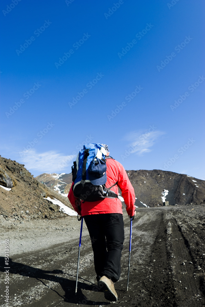 one hiker with poles walking footpath