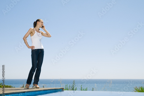 Frau steht am Pool und telefoniert © Jonas Glaubitz