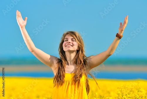 young woman on rape field in bloom