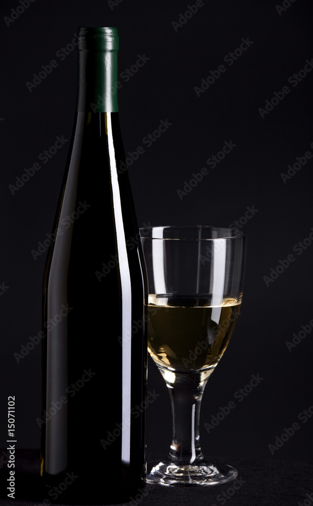 Wine bottle and glass on black background Wine bottle and glass on black background