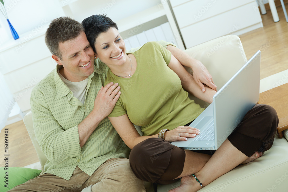 Couple using laptop at home Couple using laptop at home
