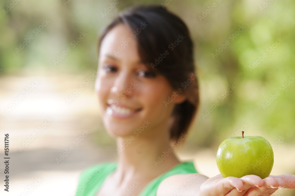 young woman with green apple, smiling and looking in camera