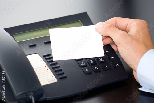 hand with white card and a telephone
