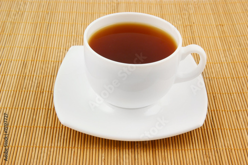 White cup of tea on wooden background