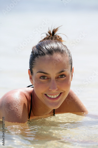 Portrait d'une jeune femme étendue dans l'eau à la plage