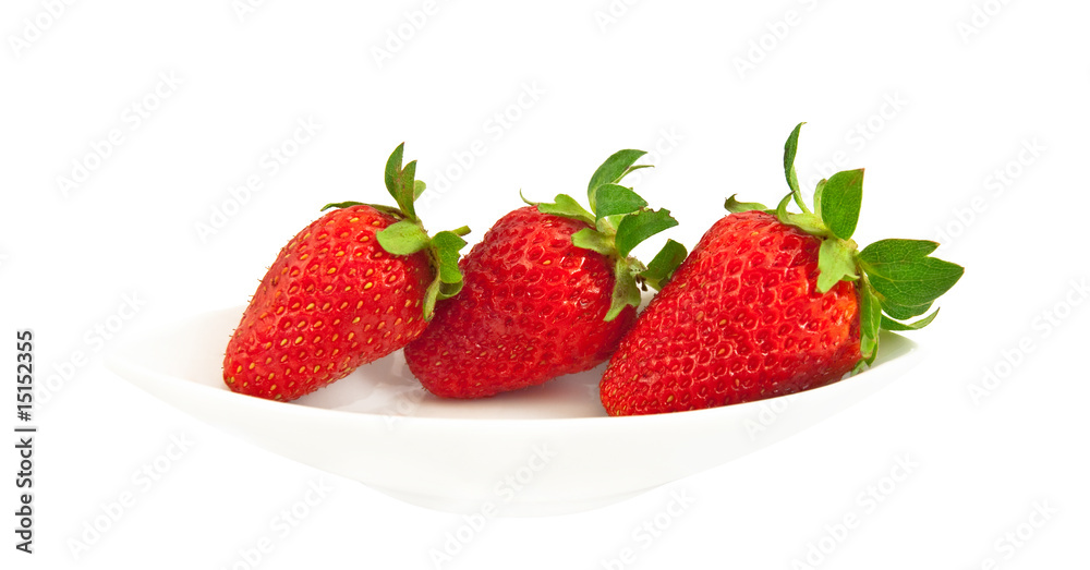 Three ripe strawberries on a white plate