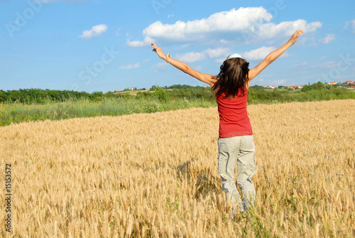 Happy girl jumping in wheat field