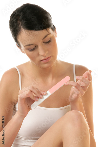 Portrait of young woman buffing her nail photo