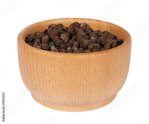 black dry pepper is in a wooden dish