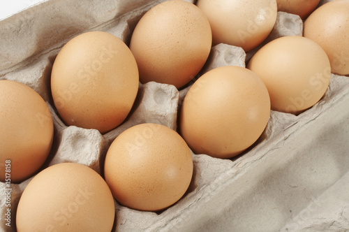A close-up shot of a carton of eggs on a white background