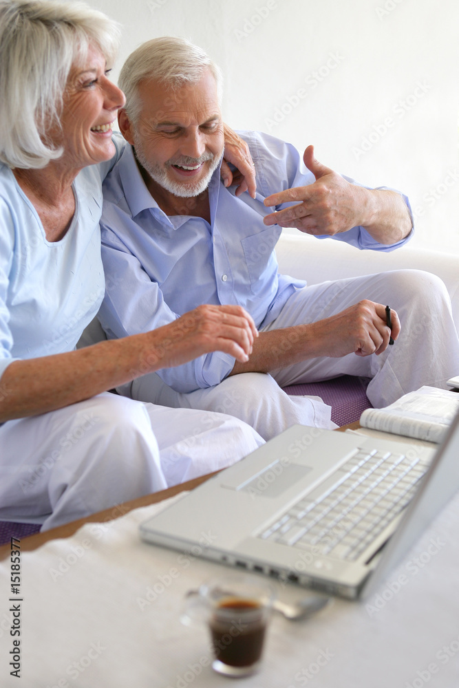 Couple de seniors souriants connectés à une webcam Couple de seniors souriants connectés à une webcam