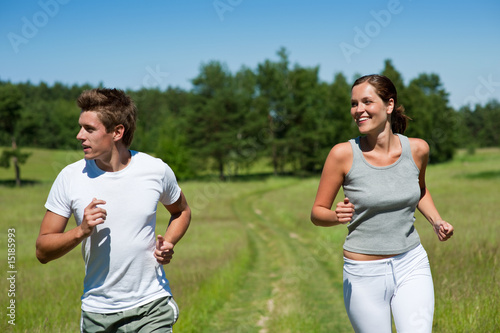 Sportive man and woman jogging outdoors