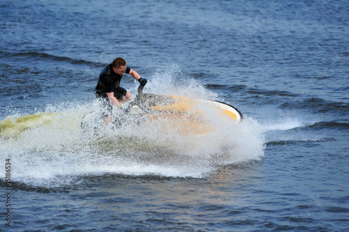 Young man riding jet ski