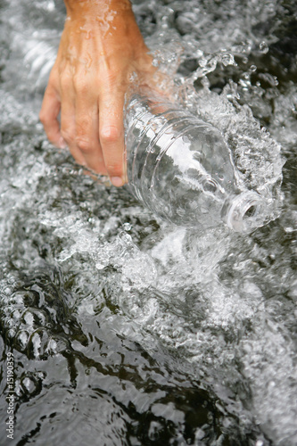 Personnage remplissant de l'eau dans une bouteille en plastique photo