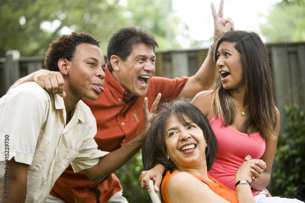 Interracial family making silly gestures posing for photograph Interracial family making silly gestures posing for photograph