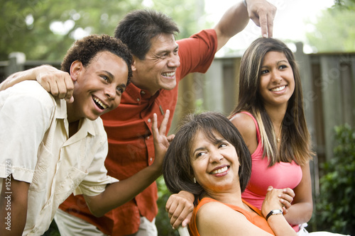 Interracial family making silly gestures posing for photograph