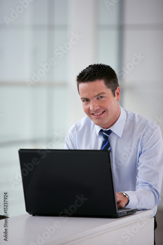 Commercial en costume devant un ordinateur portable