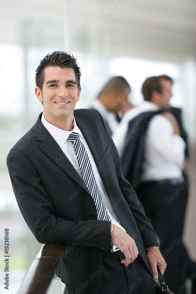 Cadre commercial souriant devant un groupe de commerciaux Cadre commercial souriant devant un groupe de commerciaux