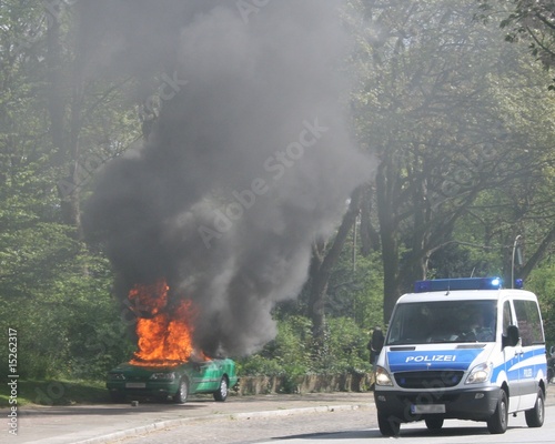 Brennendes Polizeiauto mit Mannschaftswagen