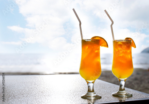 two glasses of orange juice on sky background