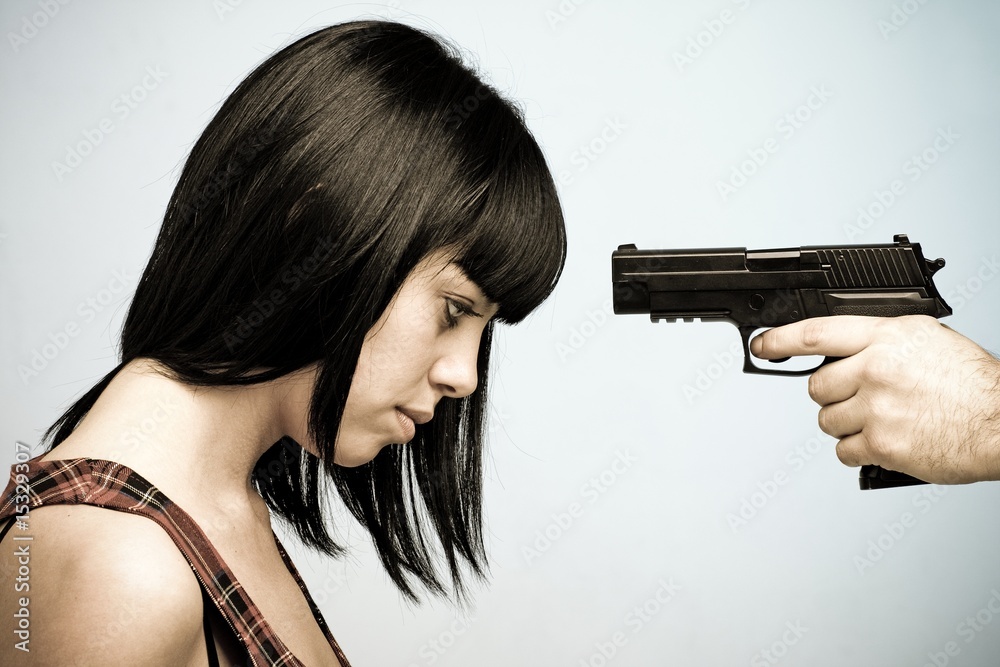 Innocent victim. Young beautiful woman and gun. Innocent victim. Young beautiful woman and gun.