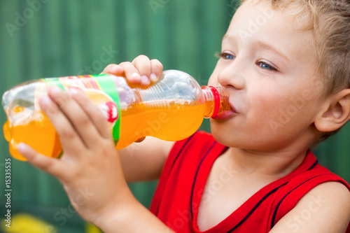 Boy drinking unhealthy bottled soda