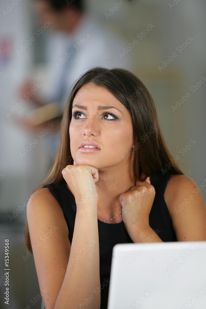 Femme inquiète et pensive devant un ordinateur portable