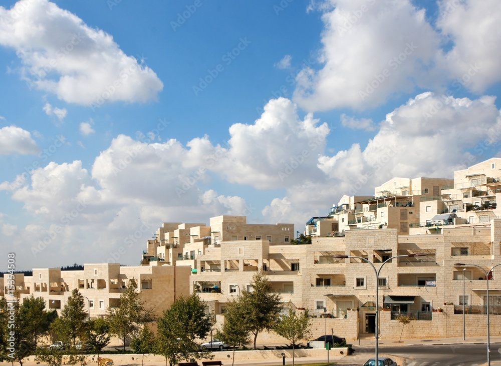 Street of new apartment buildings under blue cloudy sky