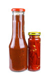 Bottles with tomato ketchup and marinated red hot chili peppers