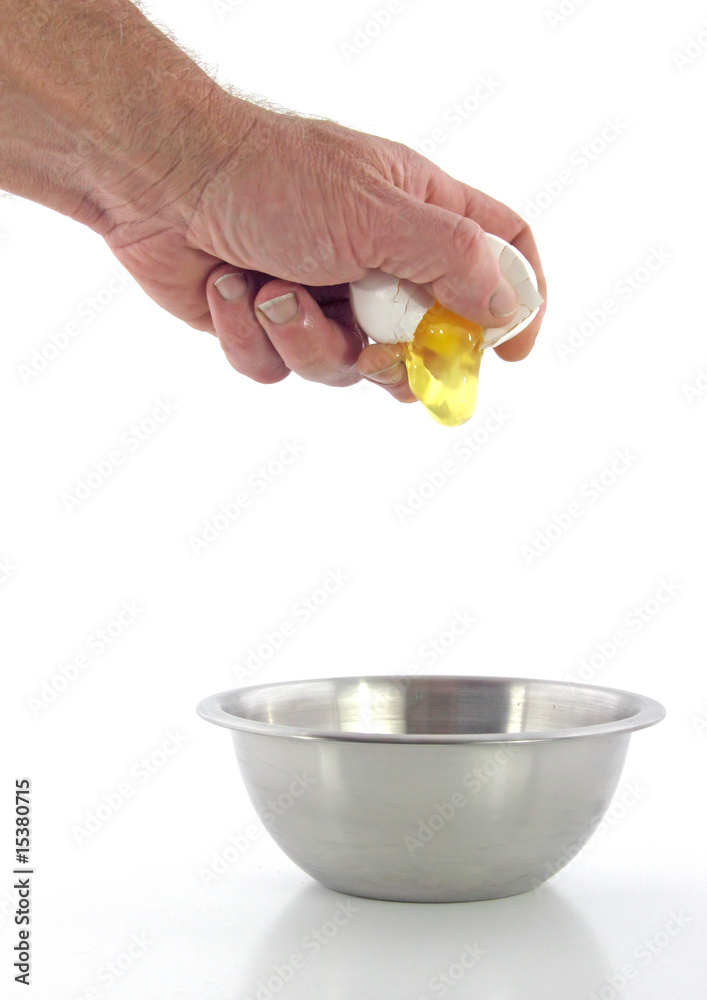Man's hand cracking egg into bowl Man's hand cracking egg into bowl